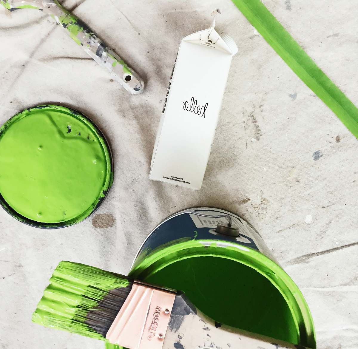 paint container A green paint can and brush next to a carton of Boxed Water 